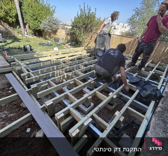 עבודת בניית דק עץ בגינה עם אנשים עובדים